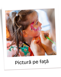 Little girl getting pink glitter face paint applied to her cheek by a painter, close-up detail of the face-painting activity, colorful outfit visible in background